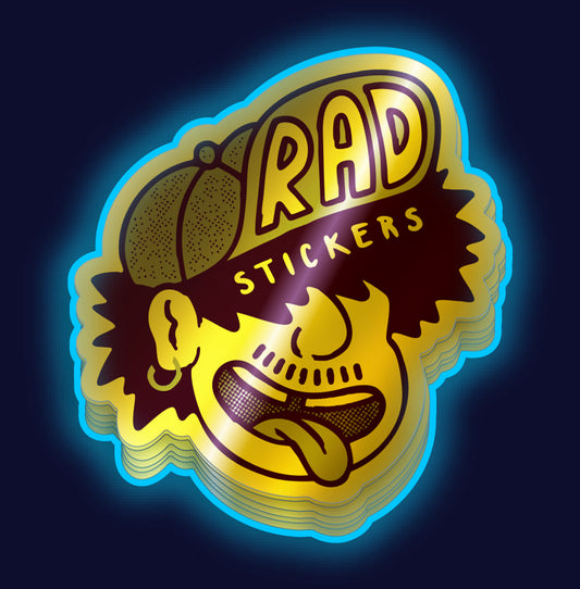 Stack of custom metallic gold 'Rad Stickers' with the dood design on a dark background