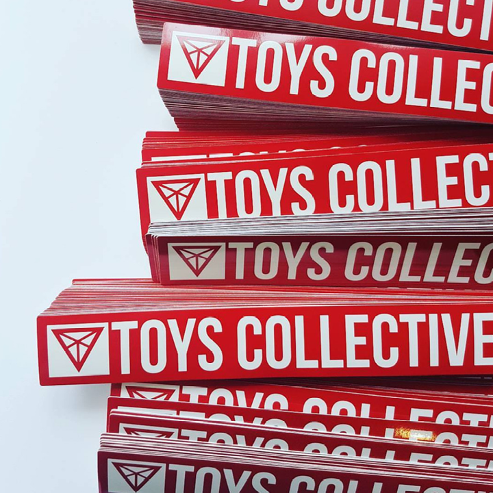 Stack of red and white 'Toys Collective' stickers on a white background