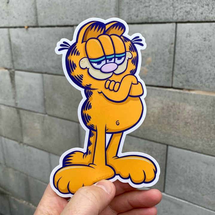 Die-cut sticker of a cartoon character held against a tiled wall