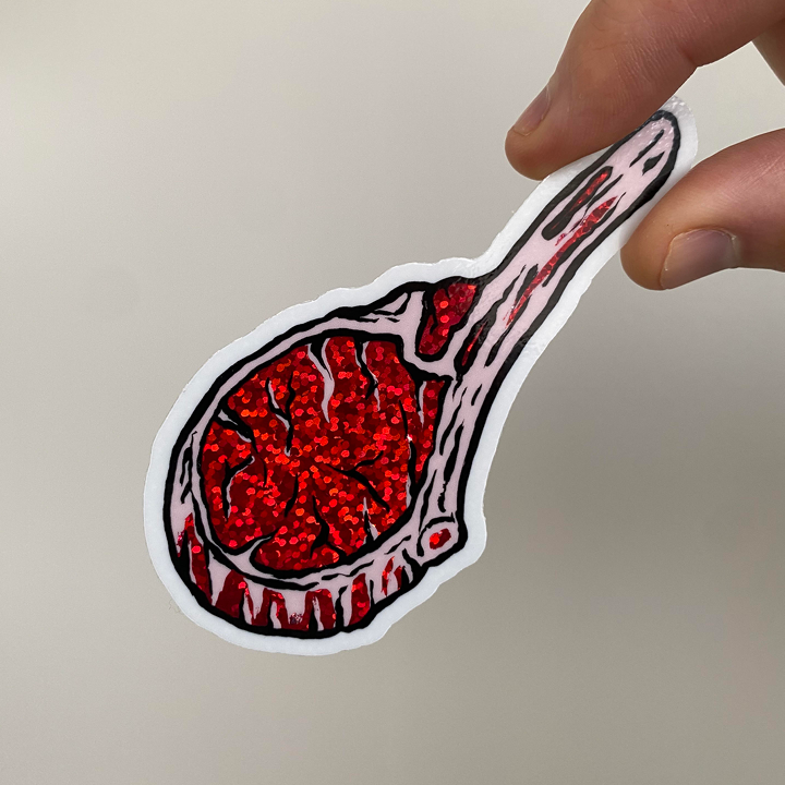 Hand holding a lamb chop glitter sticker