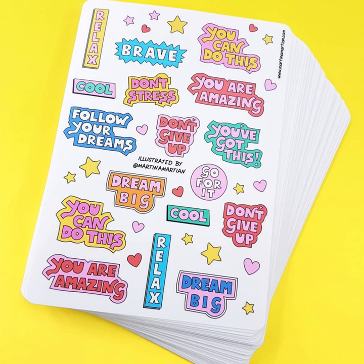 Stack of colorful motivational stickers on a sticker sheet with yellow background